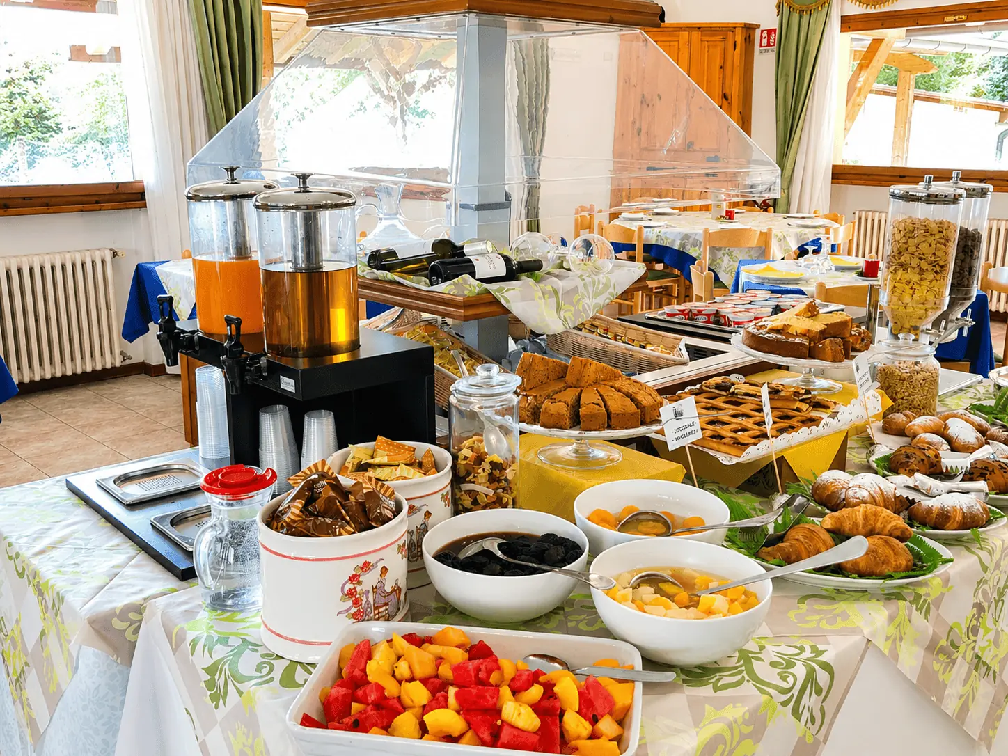 Dettaglio del buffet della colazione, con succhi, torte fatte in casa e frutta