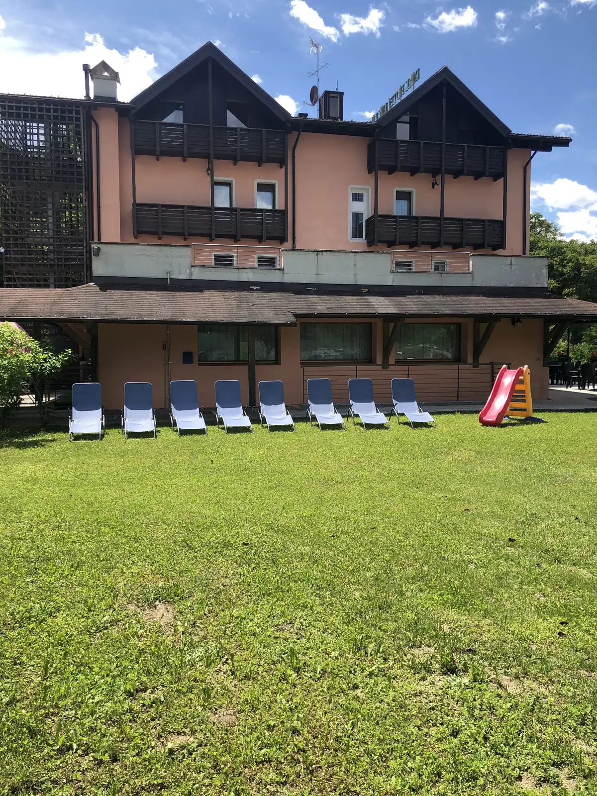 Il giardino del Park Hotel Bellevue, con lettini prendisole e scivolo per bambini